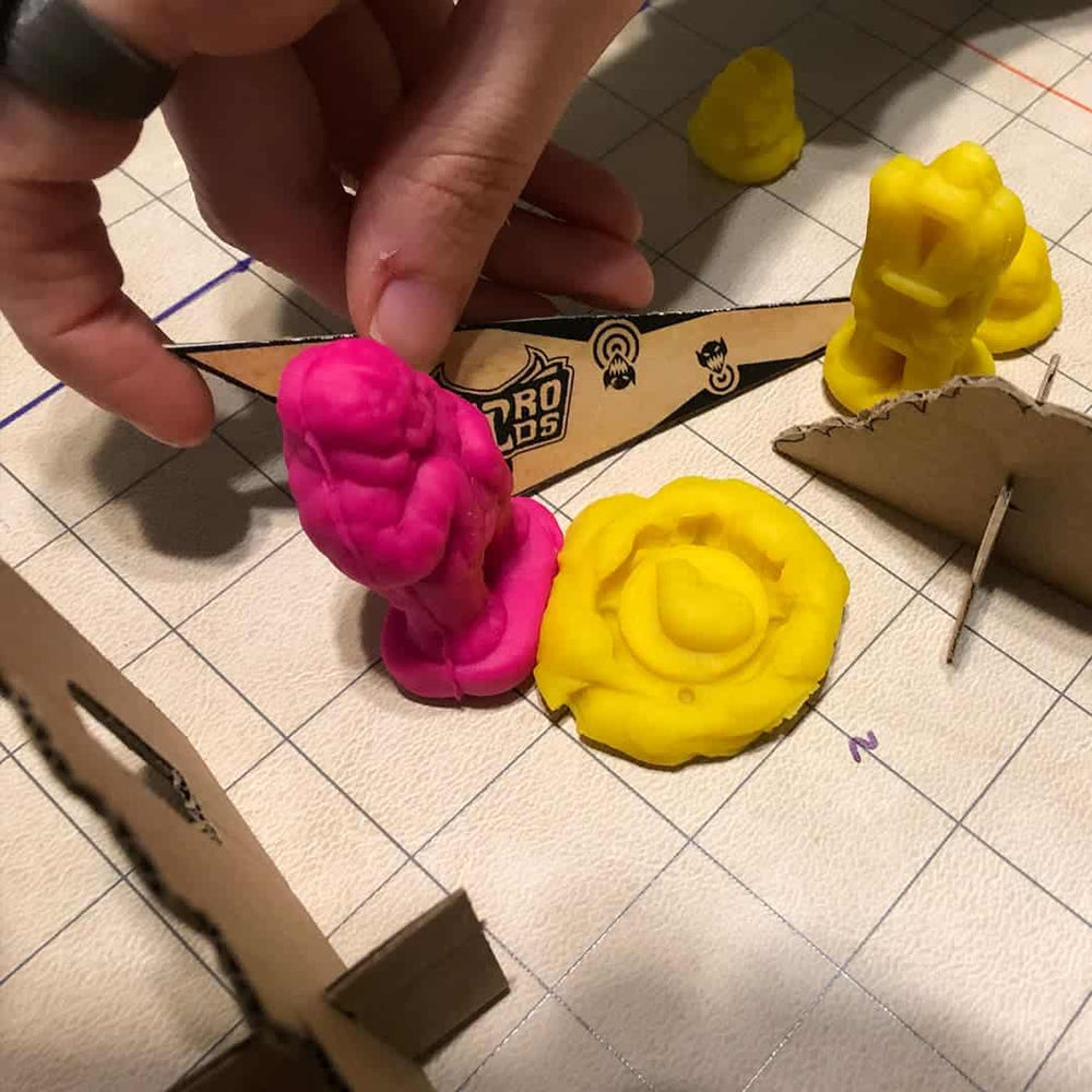 Two play doh like clay miniatures being played in a playtest of the kid friendly wargame Necromolds.