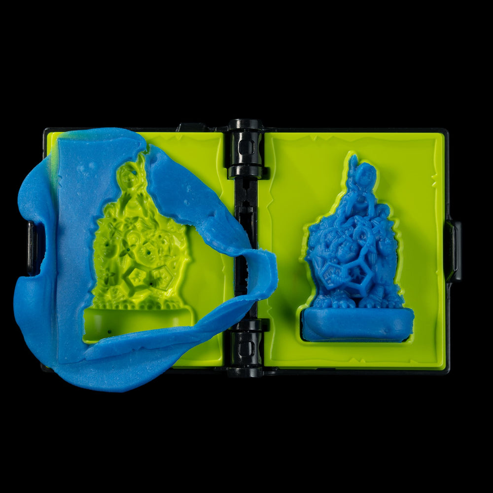 
                  
                    A spellbook shaped clay mold toy used in the Necromolds wargame to mold clay minis in the shape of creepy monsters. The clay is similar to blue play doh.
                  
                