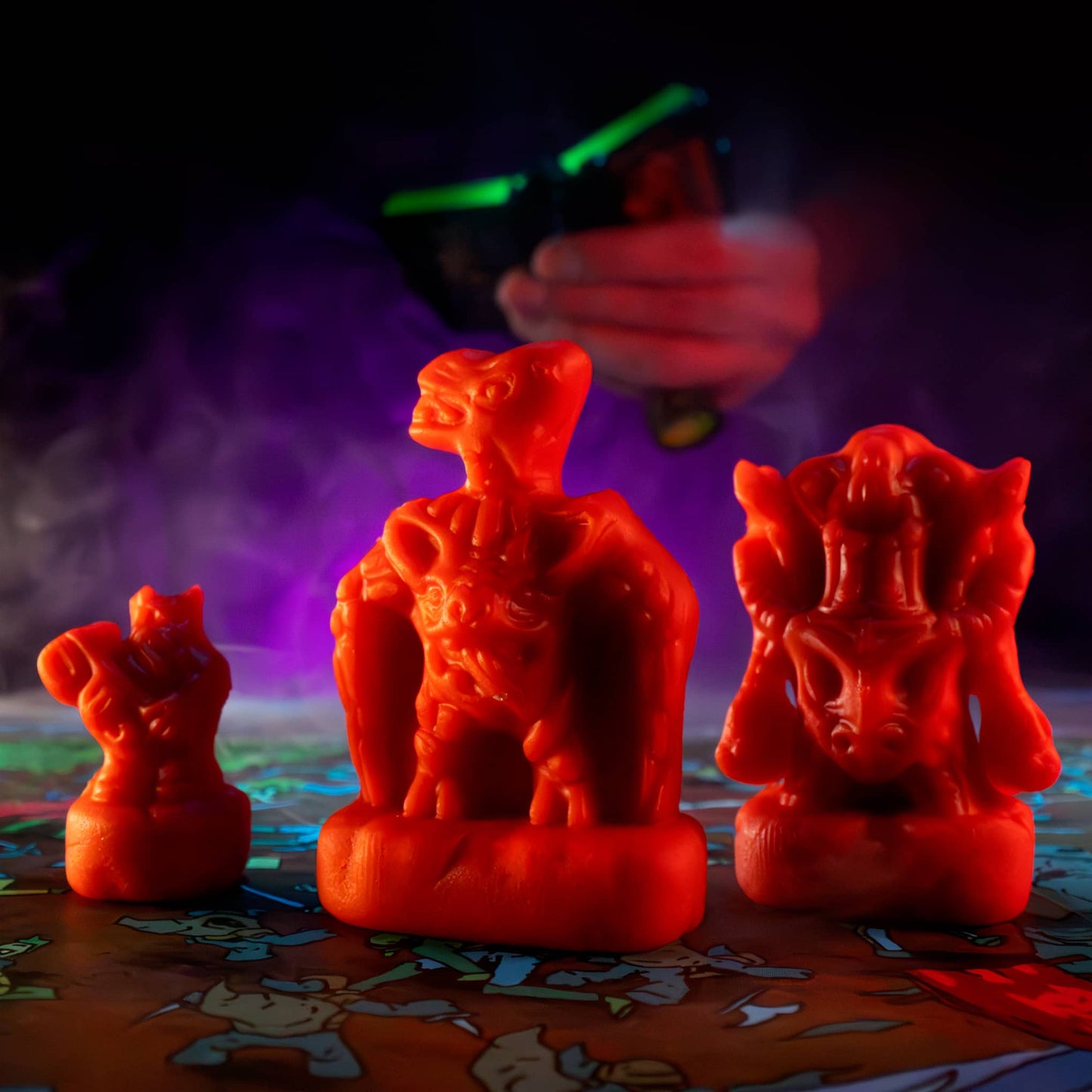 
                  
                    Three clay minis in the shape of creepy monsters that were molded from clay molds. The clay is similar to red play doh. The minis are used in the Necromolds wargame.
                  
                