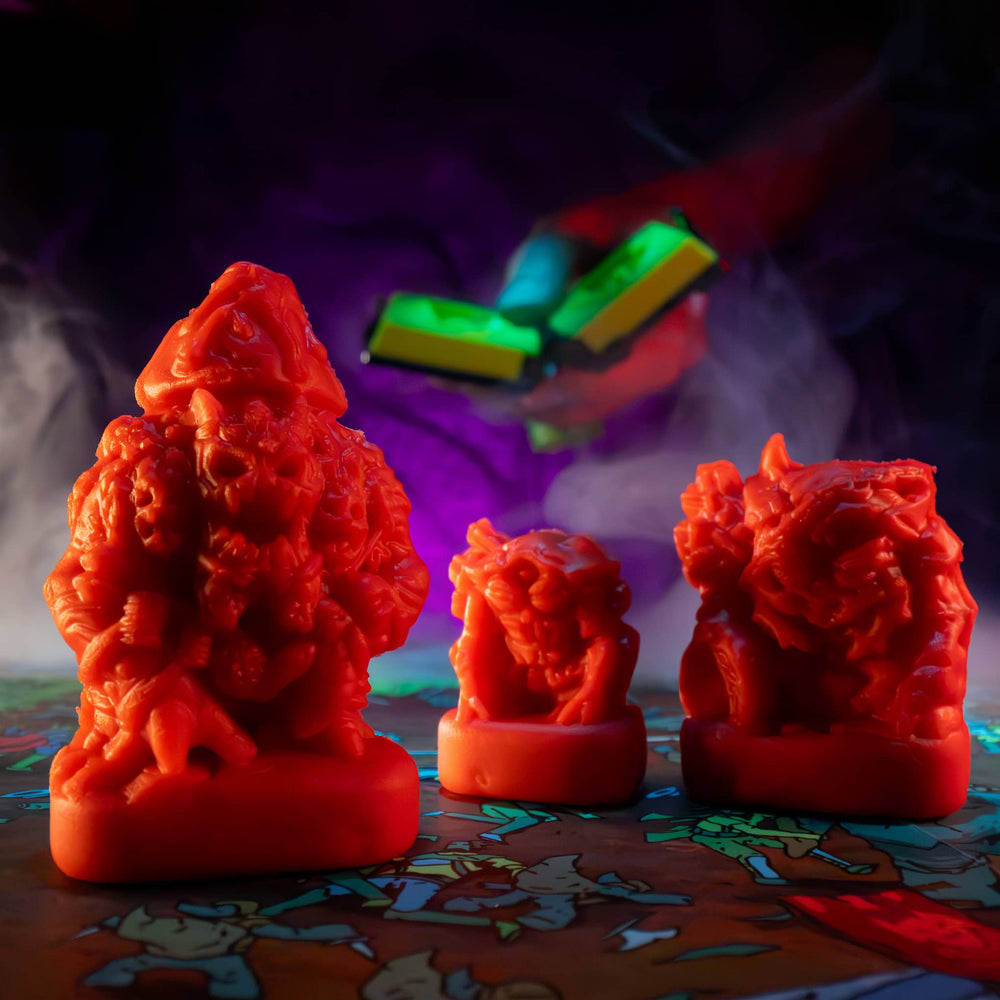 
                  
                    Three clay minis in the shape of creepy monsters that were molded from clay molds. The clay is similar to red play doh. The minis are used in the Necromolds wargame.
                  
                