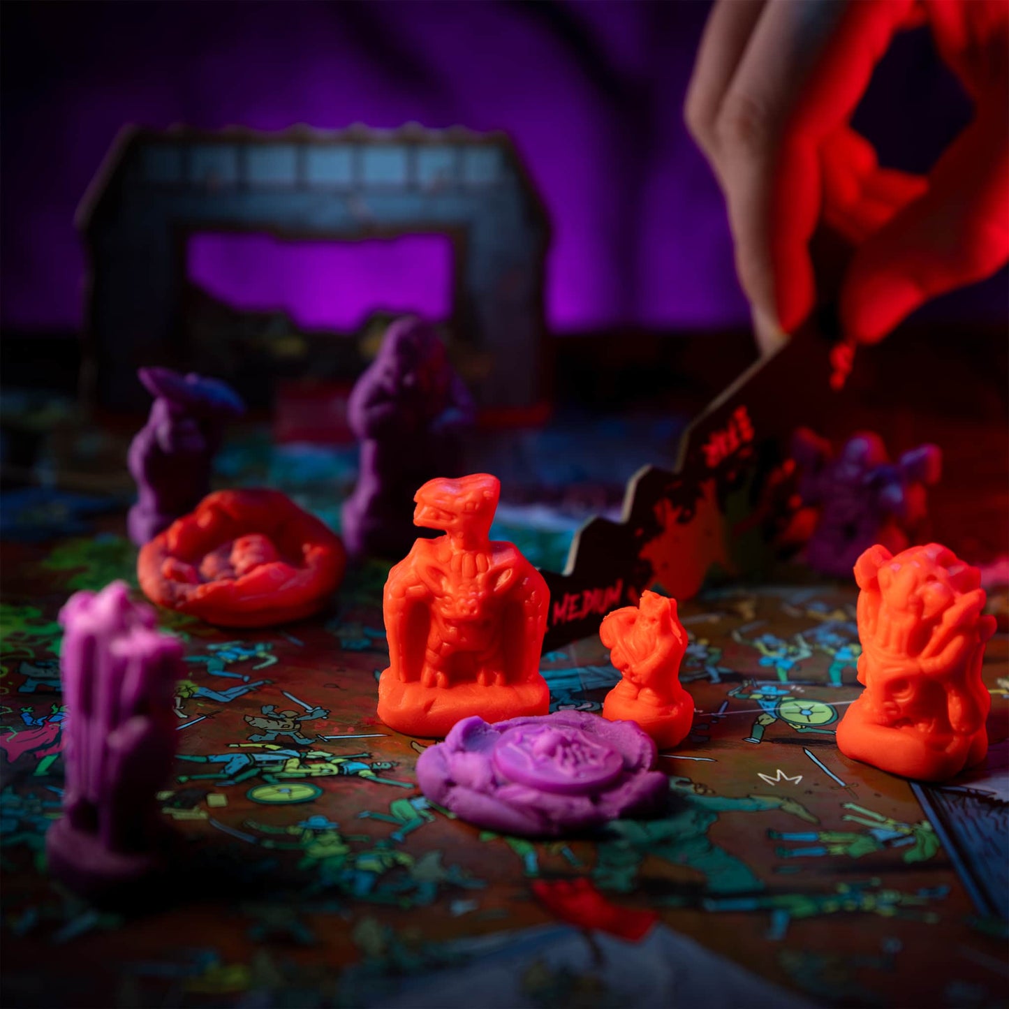 
                  
                    Red clay minis of Batadactyl and Mongeragon (compare to play dough) standing near a smashed purple monster in a wargame
                  
                