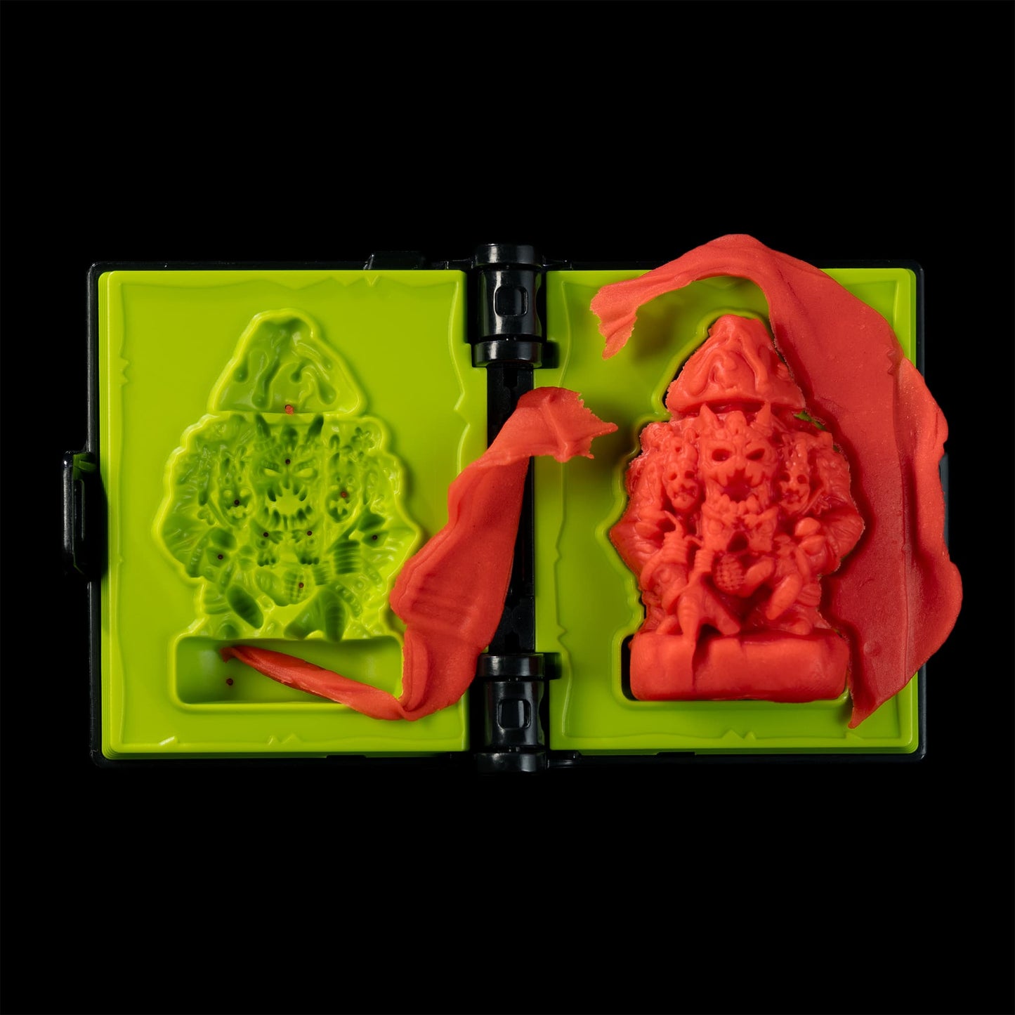 
                  
                    Spellbook-shaped clay mold toy creating a Magmass mini from red clay (compare to play dough) in a Necromolds game
                  
                