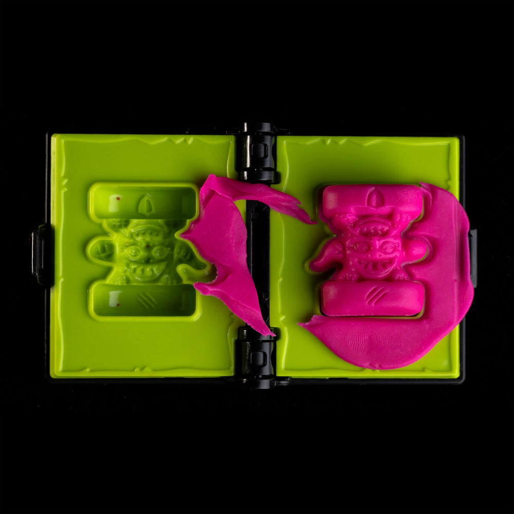 
                  
                    A spellbook shaped clay mold toy used in the Necromolds wargame to mold clay minis in the shape of creepy monsters. The clay is similar to pink play doh.
                  
                